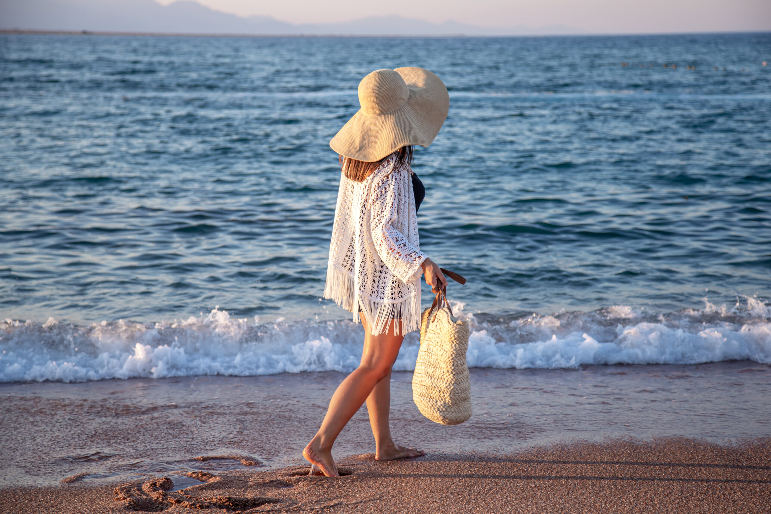 mujer andando por la orilla de la playa